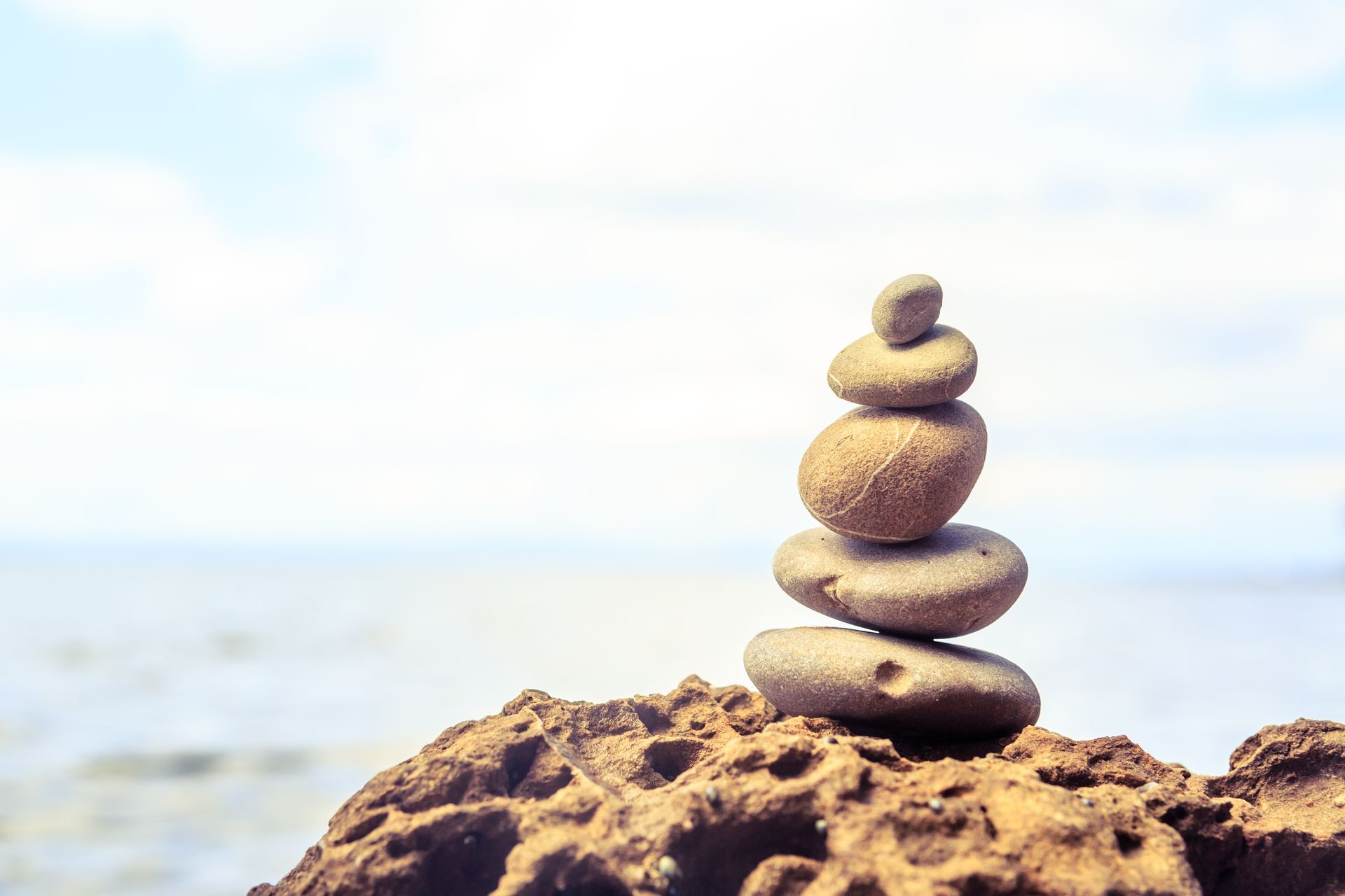 Stones balance and wellness retro spa concept, inspiration, zen-like and well being tranquil composition. Close-up of white pebbles stack over blue sea